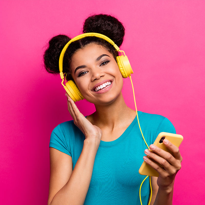 A young lady with headsets listening to overhead music by Spectrio in the USA