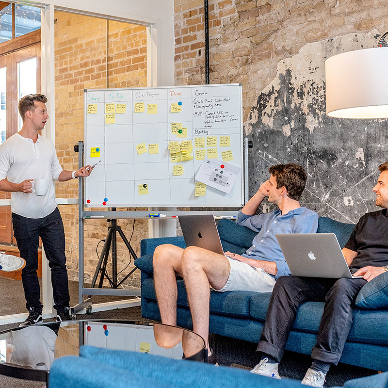 Team collaborating in a modern office using a whiteboard for project planning in the USA.