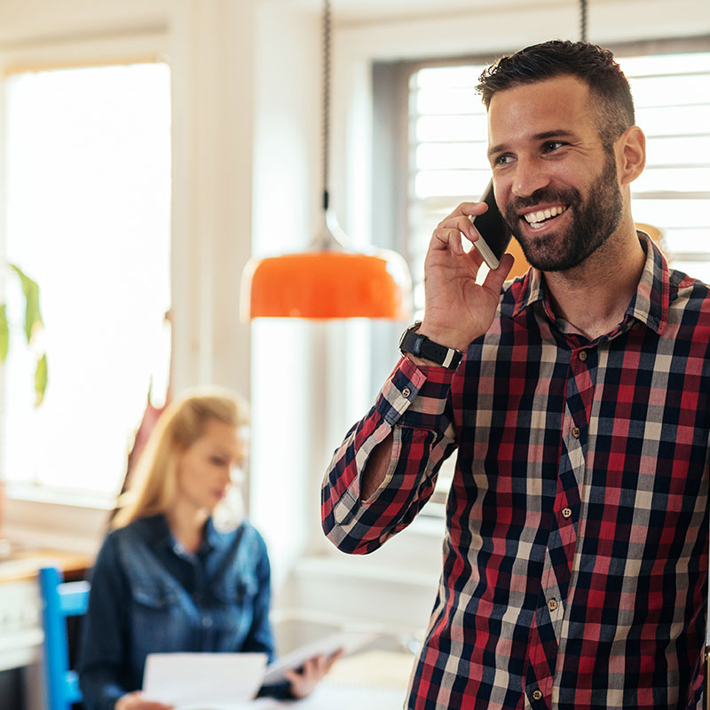 A man using his cell phone and listening to on-hold messaging