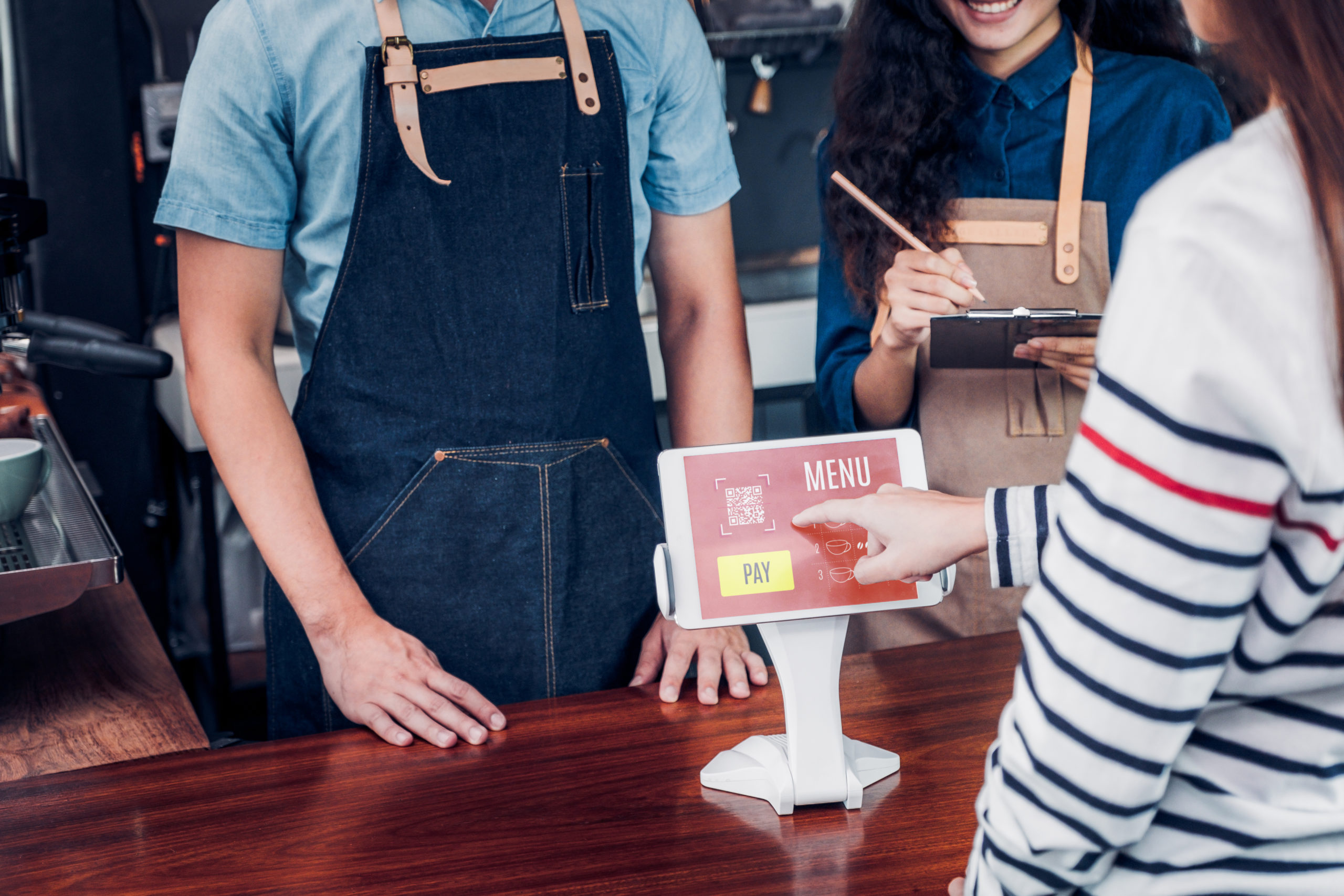 A person using a digital kiosk to make a payment at a restaurant in the USA