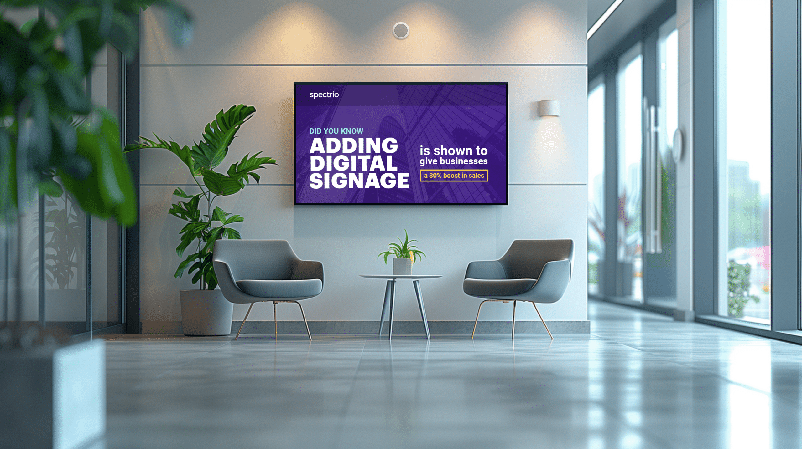 Interior of a waiting room with two chairs, a table, and I digital sign promoting Spectrio digital Signage